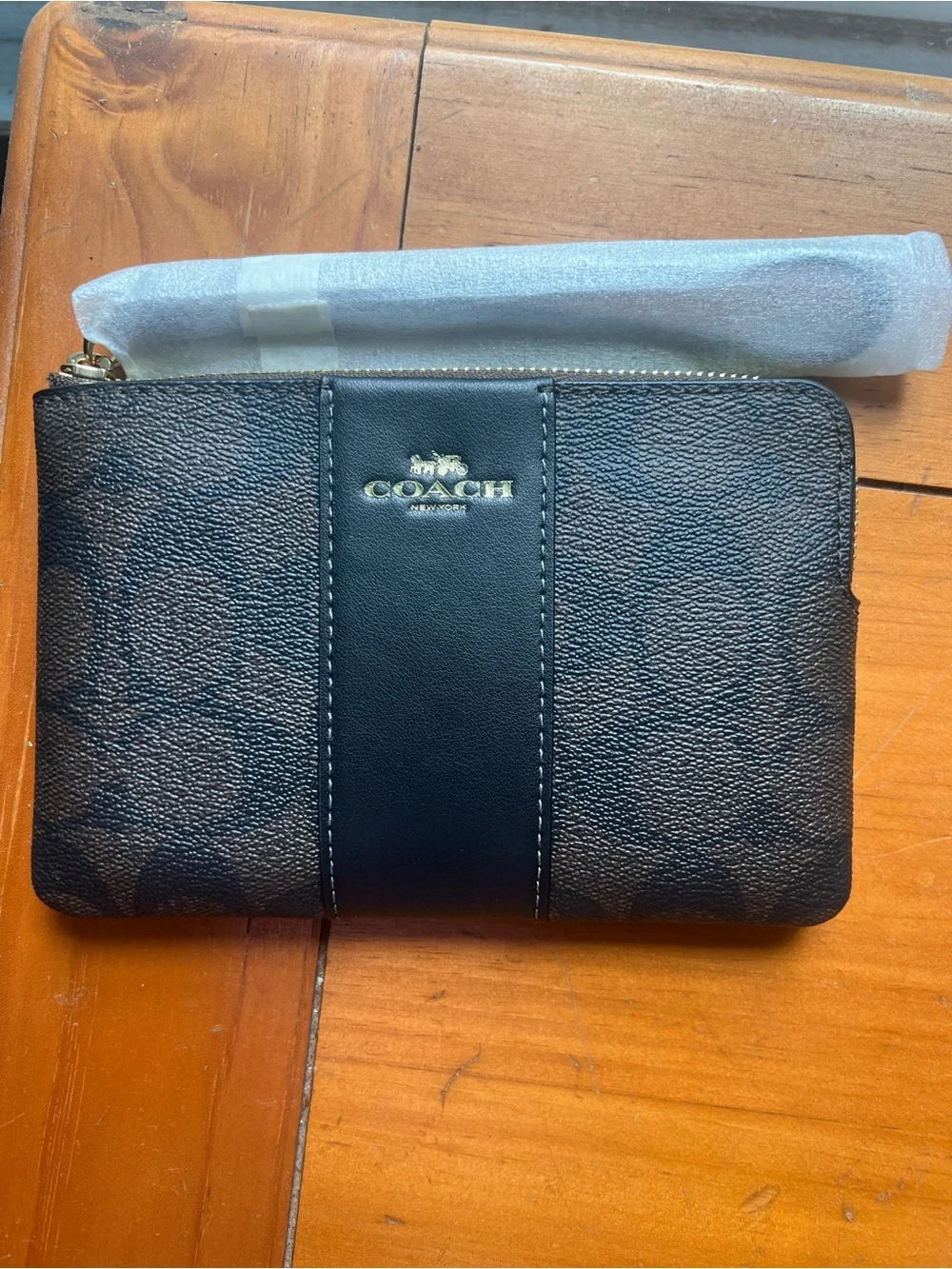 COACH corner zip wristlet in signature C pattern brown and black